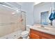 Bright bathroom featuring a glass shower enclosure and a wooden vanity with sink at 4408 W Heyerdahl Dr, New River, AZ 85087
