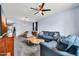 Spacious living room with plush carpet, ceiling fan, and comfortable blue sofa set at 4408 W Heyerdahl Dr, New River, AZ 85087