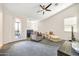 Bright main bedroom with a sitting area, ceiling fan, and access to a private balcony at 4408 W Heyerdahl Dr, New River, AZ 85087
