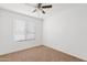 Empty bedroom with a large window, neutral carpet, and a ceiling fan at 540 W La Donna Dr, Tempe, AZ 85283
