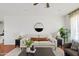 Comfortable living room featuring a sofa, wood floors, and a modern decorative mirror at 540 W La Donna Dr, Tempe, AZ 85283