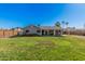 A large, well-maintained backyard featuring green grass and mature trees at 5624 W Villa Theresa Dr, Glendale, AZ 85308
