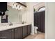 Bathroom featuring double sinks, granite countertops, and dark wood cabinetry at 5624 W Villa Theresa Dr, Glendale, AZ 85308