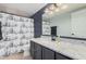 Full bathroom featuring granite countertops, updated fixtures, and a stylish nautical-themed shower curtain at 5624 W Villa Theresa Dr, Glendale, AZ 85308