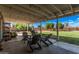 Large covered patio with string lights and multiple seating options overlooks a spacious backyard at 5624 W Villa Theresa Dr, Glendale, AZ 85308