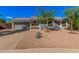 Charming single-Gathering home boasts a well-maintained front yard with mature trees and desert landscaping at 5624 W Villa Theresa Dr, Glendale, AZ 85308