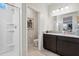 Well-lit bathroom with a walk-in shower, granite countertop vanity with double sinks, and neutral tile flooring at 5806 E Axle Ln, San Tan Valley, AZ 85140