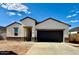 A single-story home featuring a stucco exterior, a dark garage door, and a well-maintained front yard at 5806 E Axle Ln, San Tan Valley, AZ 85140