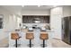Bright, contemporary kitchen featuring stainless steel appliances, dark cabinets, granite countertops, and a breakfast bar with seating at 5806 E Axle Ln, San Tan Valley, AZ 85140