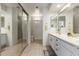 Clean bathroom featuring double sinks, white cabinets, a large mirror, and a separate shower area at 5830 E Mckellips Rd # 101, Mesa, AZ 85215