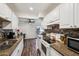 Kitchen featuring white cabinets, granite countertops, tile backsplash, and wood-look flooring at 5923 W Townley Ave, Glendale, AZ 85302