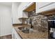 A close-up of the kitchen sink with bronze granite countertops and a matching backsplash at 5923 W Townley Ave, Glendale, AZ 85302