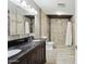 Bathroom featuring tiled walls, walk-in shower, and double sink vanity with granite counters at 6814 N 14Th St, Phoenix, AZ 85014