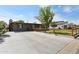 Home exterior with a wide driveway, well-kept lawn and trees in the yard at 6814 N 14Th St, Phoenix, AZ 85014