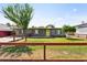 Charming home with a well-manicured lawn, wooden fence, and eye-catching yellow front door at 6814 N 14Th St, Phoenix, AZ 85014