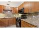 Modern kitchen showcasing granite countertops, wooden cabinets, and stainless steel appliances at 6814 N 14Th St, Phoenix, AZ 85014