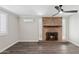 Living room featuring a striking brick fireplace, wood floors, and a modern ceiling fan at 6814 N 14Th St, Phoenix, AZ 85014