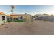 Residential backyard with sparse vegetation featuring a single-story home, mature trees, and a storage shed at 6960 W Berkeley Rd, Phoenix, AZ 85035
