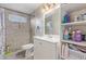 Tiled bathroom featuring a step-in shower with a gray vanity and open shelving for storage at 6960 W Berkeley Rd, Phoenix, AZ 85035
