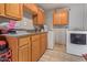 Functional laundry area featuring wood cabinets and countertop space with tile flooring and appliances at 6960 W Berkeley Rd, Phoenix, AZ 85035