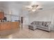 Open-concept living room with tile floors, ceiling fan, and island with breakfast bar at 6960 W Berkeley Rd, Phoenix, AZ 85035