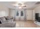 Neutral living room featuring tile floors, ceiling fan, and a large window at 6960 W Berkeley Rd, Phoenix, AZ 85035