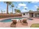 Inviting backyard with a pool, lounge chairs, lush landscaping, and a charming privacy fence at 710 E Hayward Ave, Phoenix, AZ 85020
