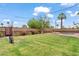 Large backyard with green grass, mature trees, manicured landscaping, and a privacy fence at 710 E Hayward Ave, Phoenix, AZ 85020