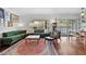 Inviting living room featuring hardwood floors, a plush green sofa, and views of the backyard pool at 710 E Hayward Ave, Phoenix, AZ 85020