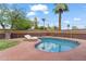 Private backyard with a kidney-shaped pool, lounge chairs, palm trees, and a privacy fence at 710 E Hayward Ave, Phoenix, AZ 85020