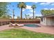 Lush backyard with a serene pool, lounge chairs, palm trees, and mature landscaping, perfect for relaxation at 710 E Hayward Ave, Phoenix, AZ 85020
