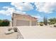 Spacious two-story home featuring a three-car garage and desert landscaping with gravel and cactus at 7472 E Black Rock Rd, Scottsdale, AZ 85255