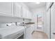 This bright laundry room includes a washer, dryer, cabinets and a door to the outside at 7472 E Black Rock Rd, Scottsdale, AZ 85255