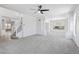 Spacious carpeted living room with staircase, ceiling fan, and large windows offering natural light at 7472 E Black Rock Rd, Scottsdale, AZ 85255