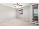 Neutral bedroom featuring a ceiling fan, a window and a glass door leading to a balcony at 9148 W Meadow Dr, Peoria, AZ 85382