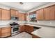 Well-lit kitchen featuring stainless steel appliances, light countertops, and plentiful wood cabinetry at 9148 W Meadow Dr, Peoria, AZ 85382