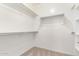 Spacious walk-in closet featuring neutral carpet and white walls with shelving racks for optimal storage at 9148 W Meadow Dr, Peoria, AZ 85382