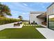 Spacious backyard with artificial turf, patio seating, and a view of the modern home's architecture at 1013 W Ardmore Rd, Phoenix, AZ 85041