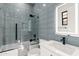 Bathroom featuring blue glass shower tiles, glass shower door, and black hardware at 1013 W Ardmore Rd, Phoenix, AZ 85041