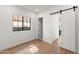 Modern bedroom features light hardwood floors, natural light, and sliding barn door at 1013 W Ardmore Rd, Phoenix, AZ 85041