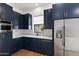 Modern kitchen boasts navy cabinets, stainless steel appliances, and herringbone backsplash at 1013 W Ardmore Rd, Phoenix, AZ 85041