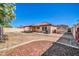 Wide shot of the backyard with covered patio, rock landscaping, and enclosed sand box at 10541 W Foothill Dr, Peoria, AZ 85383