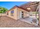 Corner shot of the backyard featuring a covered patio, rock landscaping, and view of the back of the house at 10541 W Foothill Dr, Peoria, AZ 85383