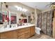 Bathroom with double sink vanity, warm color palette, decorative accents and patterned shower curtain at 10541 W Foothill Dr, Peoria, AZ 85383