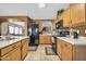 Traditional kitchen with oak cabinets, black appliances, and white countertops offering ample space at 10541 W Foothill Dr, Peoria, AZ 85383