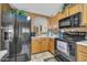 Functional kitchen area featuring maple cabinets, black appliances, neutral countertops, and tile flooring at 10541 W Foothill Dr, Peoria, AZ 85383