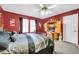 Main bedroom featuring bold red walls, a ceiling fan, and coordinated furniture set at 10541 W Foothill Dr, Peoria, AZ 85383