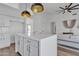 Kitchen island featuring white cabinetry and countertops, pendant lights, and adjacent living space at 1071 N Danyell Dr, Chandler, AZ 85225