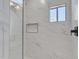 The sleek shower features white marble style tiling, a window, and a shower niche at 1071 N Danyell Dr, Chandler, AZ 85225