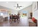 Bright dining area features a ceiling fan, wood-look tile floor, and sliding glass doors to the backyard at 11207 W Turney Ave, Phoenix, AZ 85037